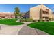 Tan two-story condo building with grassy areas and walkways at 14203 N 19Th Ave # 1051, Phoenix, AZ 85023