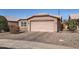 Front view of a tan house with a two-car garage and desert landscaping at 1486 E Augusta Ave, Chandler, AZ 85249