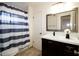 Bathroom with double vanity, striped shower curtain, and a large mirror at 1636 E Juanita Ave, Mesa, AZ 85204