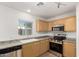 Kitchen with light wood cabinets, stainless steel appliances, and tile floors at 17840 W Calavar Rd, Surprise, AZ 85388