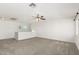 Spacious loft area with neutral carpeting and ceiling fan at 17840 W Calavar Rd, Surprise, AZ 85388