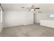 Spacious loft area with neutral carpeting and a ceiling fan at 17840 W Calavar Rd, Surprise, AZ 85388