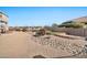 Landscaped backyard with a tiered retaining wall and artificial turf at 18672 W Santa Irene Dr, Goodyear, AZ 85338