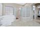 Bathroom with a large soaking tub and a glass block shower at 18672 W Santa Irene Dr, Goodyear, AZ 85338