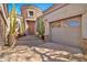 Elegant entryway with a wood door, stone accents, and large potted plants at 18672 W Santa Irene Dr, Goodyear, AZ 85338