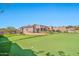 Expansive putting green with a view of the house and surrounding landscape at 18672 W Santa Irene Dr, Goodyear, AZ 85338