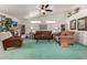 Bright living room with teal carpet, brown sofas, and a large TV at 2329 N Recker Rd # 94, Mesa, AZ 85215