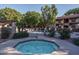 Octagonal hot tub surrounded by a patio and lush landscaping at 3031 N Civic Center Plz # 228, Scottsdale, AZ 85251