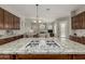 Kitchen island with granite countertop and gas cooktop, open to living area at 31847 N 53Rd St, Cave Creek, AZ 85331