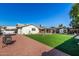 Large backyard with grassy area, patio, and fire pit at 3519 W Emig Rd, Phoenix, AZ 85053