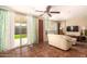 Bright living room featuring tiled floors, a comfy sofa, and sliding glass doors leading to the backyard at 3519 W Emig Rd, Phoenix, AZ 85053