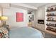 Modern bedroom with a large art piece, fireplace, and built-in shelving at 39349 N 107Th Way, Scottsdale, AZ 85262