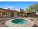 Round hot tub with stone surround, nestled in desert landscape at 39349 N 107Th Way, Scottsdale, AZ 85262