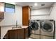 Modern laundry room with stainless steel appliances and ample storage at 39349 N 107Th Way, Scottsdale, AZ 85262