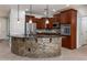 Kitchen with a curved island, dark wood cabinets, and granite countertops at 42593 W Falling Star Ct, Maricopa, AZ 85138