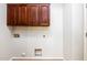 Laundry room with wooden cabinets and built-in shelving at 42593 W Falling Star Ct, Maricopa, AZ 85138