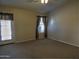 Bright bedroom with carpet flooring, window, and door at 4302 E Rockledge Rd, Phoenix, AZ 85044