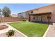 Two-story house with grassy backyard and fire pit at 43864 W Elizabeth Ave, Maricopa, AZ 85138