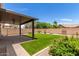 Covered patio, grassy lawn, and block wall at 43864 W Elizabeth Ave, Maricopa, AZ 85138