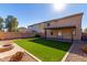 House exterior and grassy backyard with fire pit at 43864 W Elizabeth Ave, Maricopa, AZ 85138