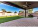 Covered patio, grassy lawn, fire pit, and block wall at 43864 W Elizabeth Ave, Maricopa, AZ 85138