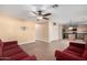 Living room with tile flooring, ceiling fan, and view of kitchen at 43864 W Elizabeth Ave, Maricopa, AZ 85138