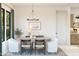 Formal dining room with oval table, chandelier, and view to backyard at 4444 N 203Rd Dr, Buckeye, AZ 85396