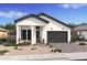 One-story home with white exterior, dark gray garage door, and landscaping at 4444 N 203Rd Dr, Buckeye, AZ 85396