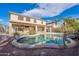 Kidney-shaped pool with a large patio and two-story house in the background at 4615 E Bent Tree Dr, Cave Creek, AZ 85331