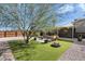 Landscaped backyard oasis with fire pit and grassy area at 4902 W Cypress St, Phoenix, AZ 85035