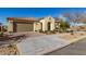 Front view of a single-story house with a tan facade and a two-car garage at 5720 S Wildrose --, Mesa, AZ 85212