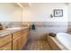 Bathroom with a tiled bathtub and wooden vanity at 6052 N 183Rd Ave, Waddell, AZ 85355