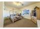 Bedroom with wooden canopy bed and adjacent bath at 6052 N 183Rd Ave, Waddell, AZ 85355