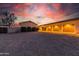 Evening view of a home with a three-car garage at 6052 N 183Rd Ave, Waddell, AZ 85355