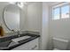 Small bathroom with black granite vanity and round mirror at 669 S Saddle St, Gilbert, AZ 85233