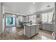 Open concept kitchen with island, grey cabinets, and hardwood floors at 7419 S 31St Dr, Phoenix, AZ 85041