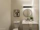 Modern bathroom with white vanity, round mirror, and black fixtures at 8413 N 55Th Ave, Glendale, AZ 85302