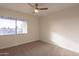 Simple bedroom with large window and ceiling fan at 8413 N 55Th Ave, Glendale, AZ 85302