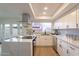 Modern kitchen with white cabinets, marble countertops, and a view of the backyard at 8413 N 55Th Ave, Glendale, AZ 85302