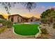 Landscaped backyard with a large green lawn and a kidney shaped pool at 9690 N 117Th Way, Scottsdale, AZ 85259