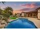 Luxury home with a large freeform pool, lush landscaping, and covered patio at 9690 N 117Th Way, Scottsdale, AZ 85259