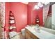 Small bathroom with red walls, a single sink and a toilet at 9690 N 117Th Way, Scottsdale, AZ 85259