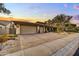 A tan-colored house with a three-car garage and nicely landscaped front yard at 9690 N 117Th Way, Scottsdale, AZ 85259