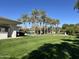 Landscaped lawn area with palm trees and clubhouse at 9690 N 117Th Way, Scottsdale, AZ 85259