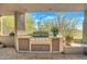 Built-in outdoor grill with stone counters and desert landscaping at 10040 E Happy Valley Rd # 1047, Scottsdale, AZ 85255