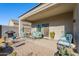 Covered patio with seating area, grill, and plants at 10421 E Cliffrose Ln, Florence, AZ 85132