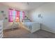 Bedroom with white bed frame and pink curtains at 10421 E Cliffrose Ln, Florence, AZ 85132