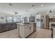 Open kitchen with white cabinets, island, and stainless steel appliances at 10421 E Cliffrose Ln, Florence, AZ 85132