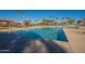 Community pool with surrounding patio and palm trees at 10421 E Cliffrose Ln, Florence, AZ 85132