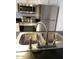 Modern kitchen features stainless steel appliances, double sink, and sleek black countertops at 1069 N 84Th Pl, Scottsdale, AZ 85257